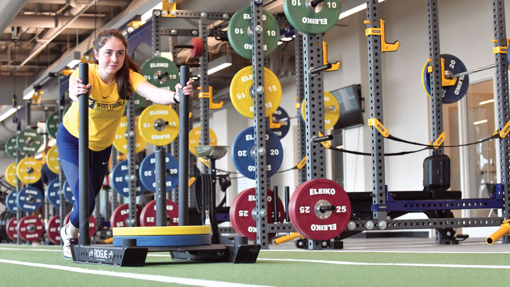 female-athlete-pushing-weights-across-room