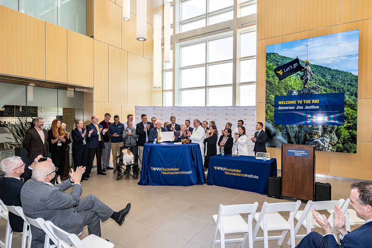 Gov. Jim Justice (center) was joined by WVU<br />
President Gordon Gee, Dr. Ali Rezai, state lawmakers,<br />
and researchers and staff members with the WVU<br />
Rockefeller Neuroscience Institute as he ceremonially<br />
signed legislation Monday (Oct. 28) providing $2 million in<br />
supplemental funding to support first-in-the-world clinical<br />
research studies at RNI.